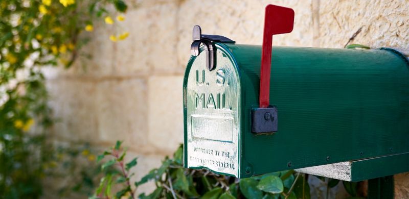 Green US post mail letter box with red flag raised up