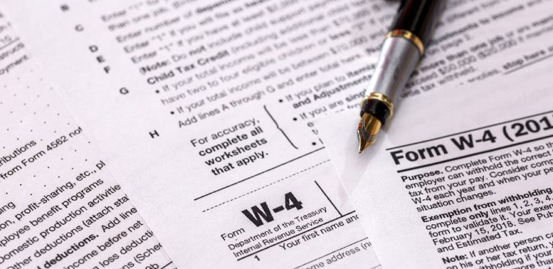 W4 tax forms with a pen laying on top
